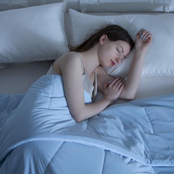 a girl deep sleep in blue cooling comforter