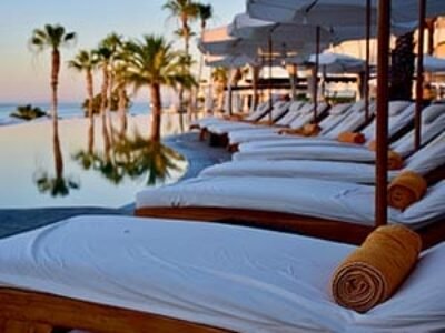 There are white lounge chairs on the beach.